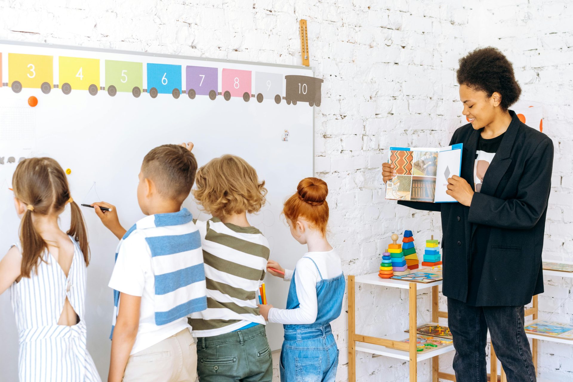 Children actively participating in classroom learning with a teacher guiding them.