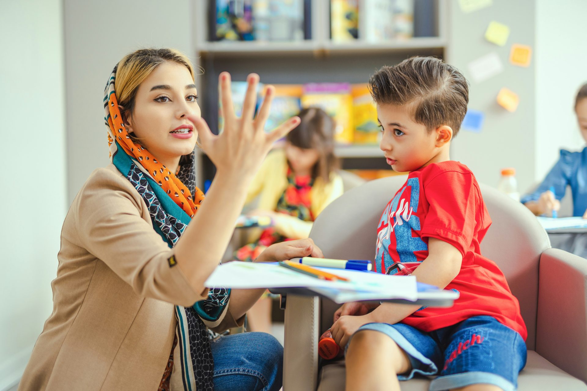 Teacher showing a child numbers with her fingers